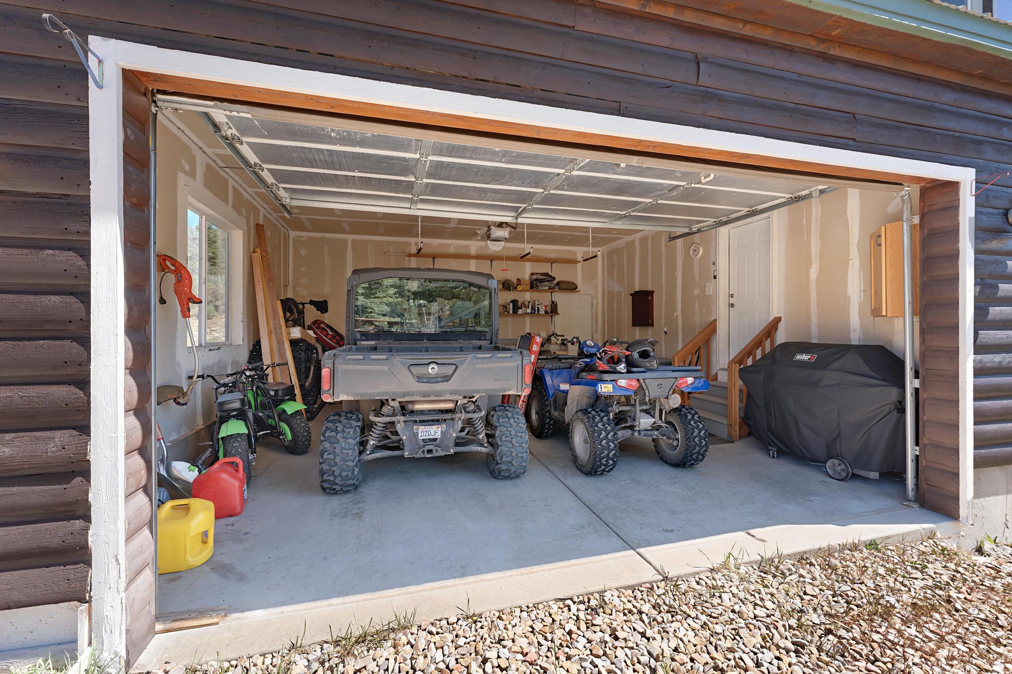 Spacious garage featuring a concrete floor, interior window, and interior access door
