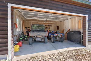 Spacious garage featuring a concrete floor, interior window, and interior access door