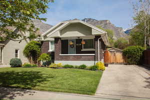 Bungalow with brick siding, a mountain view, and a porch
