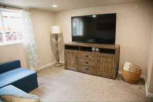 Living area featuring light colored carpet and recessed lighting