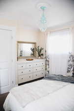 Bedroom with ornamental molding and suspended lighting