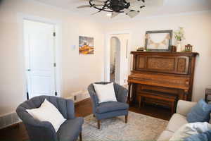 Living area featuring arched walkways, ceiling fan, wood finished floors, ornamental molding, and recessed lighting