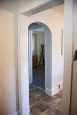 Hall with arched walkways and baseboards