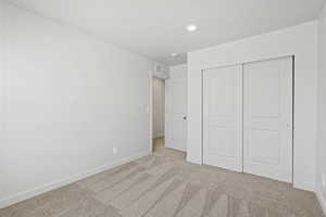 *DISCLAIMER*  Interior package and colors may vary. Unfurnished bedroom featuring light carpet and a closet