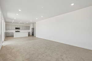 *DISCLAIMER*  Interior package and colors may vary. Unfurnished living room with light carpet and recessed lighting