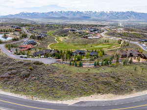 Aerial perspective of suburban area featuring a mountainous background and a golf club