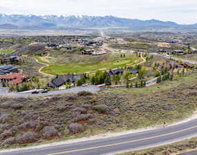 Aerial view of residential area with a mountainous background and a golf club
