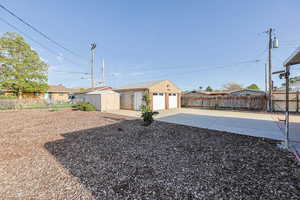Fenced backyard featuring a garage, a residential view, and a shed
