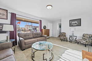 Living area with light colored carpet and baseboards