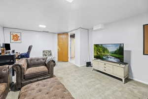 Living area with light carpet and baseboards