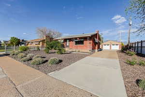 Single story home featuring an outdoor structure, brick siding, and a garage
