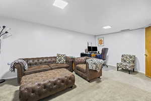 Living area featuring carpet floors and a desk