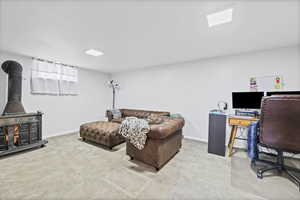 Office space with a wood stove and light carpet