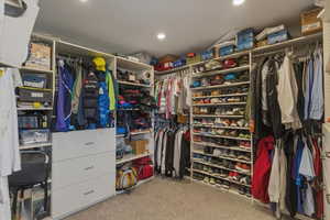 Walk in closet featuring light colored carpet