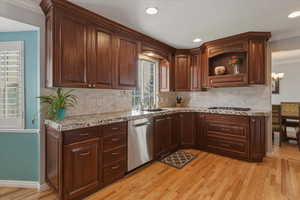 Kitchen featuring crown molding, light wood-style floors, dishwasher, recessed lighting, and open shelves