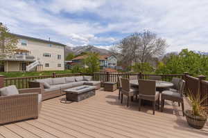 Deck featuring a fire pit, outdoor lounge area, a mountain view, and a residential view