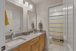 Bathroom featuring double vanity, a shower with curtain, and light tile patterned flooring