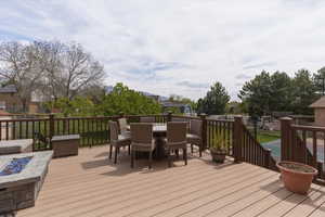 Wooden deck with outdoor dining space and a fire pit