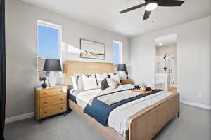 Carpeted bedroom featuring ceiling fan and connected bathroom