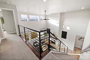Staircase with wood finished floors and recessed lighting