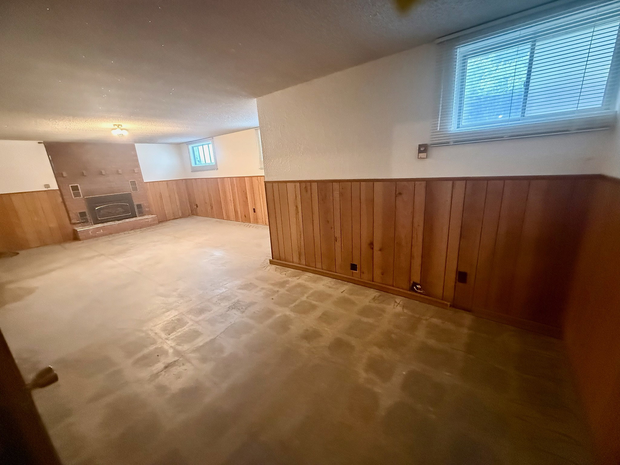 Below grade area featuring wainscoting, wooden walls, and a textured ceiling