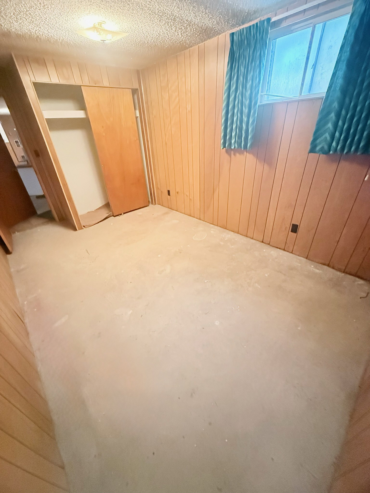 Basement featuring wooden walls and a textured ceiling