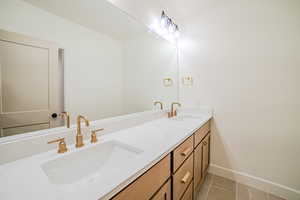 Bathroom featuring double vanity and light tile patterned flooring
