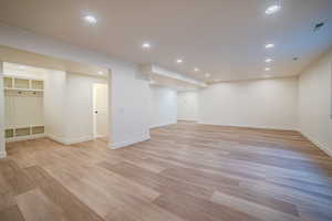 Finished below grade area with recessed lighting and light wood-style flooring
