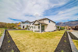 Rear view of house with a yard and a mountain view