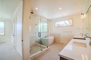 Bathroom featuring double vanity, a freestanding tub, a shower stall, and recessed lighting