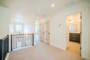 Hall featuring light carpet and hanging lights