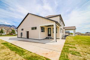 View of property exterior featuring a yard, board and batten siding, a residential view, and roof with shingles