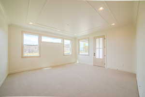 Empty room featuring carpet, recessed lighting, and crown molding