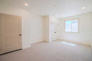 Unfurnished bedroom featuring light colored carpet and recessed lighting