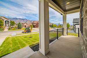 Porch with a residential view, a yard, and a mountain view
