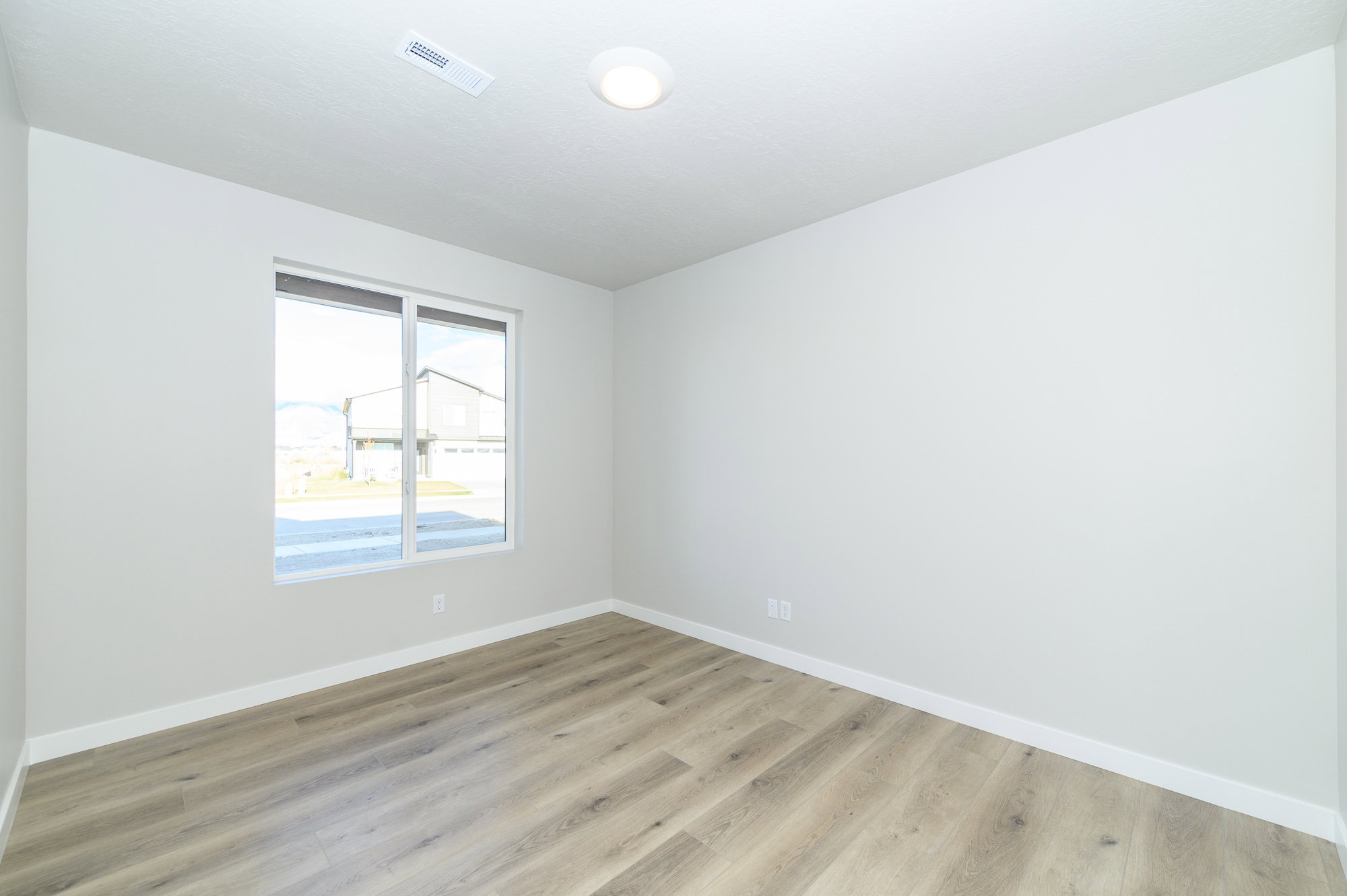 Empty room featuring baseboards and light wood finished floors