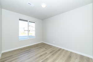 Empty room featuring baseboards and light wood finished floors