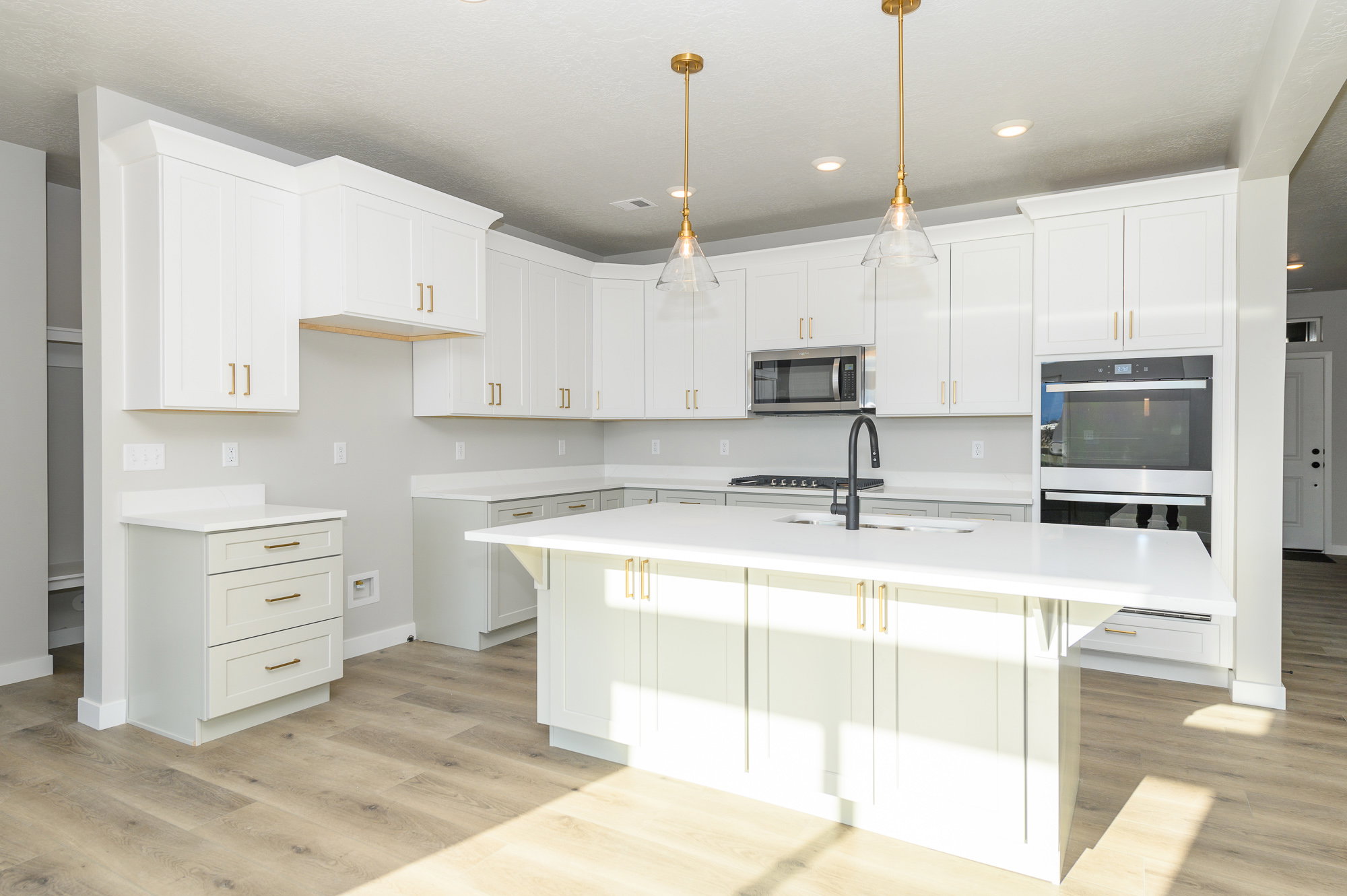 Kitchen with a kitchen island with sink, white cabinetry, a breakfast bar area, light wood-style floors, and stainless steel appliances