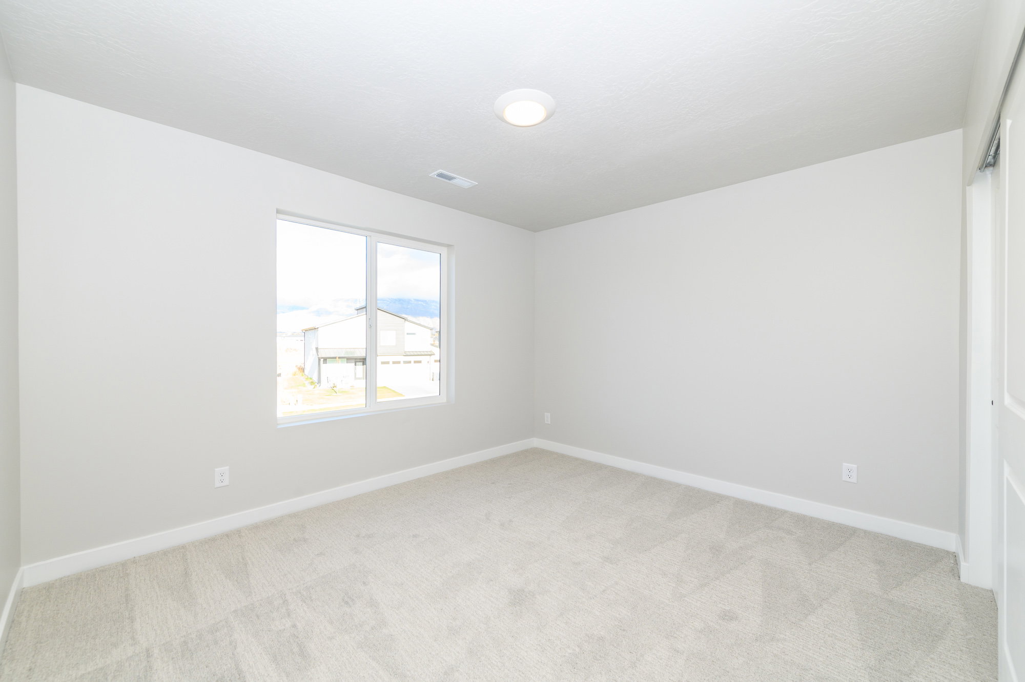 Spare room with light carpet and baseboards