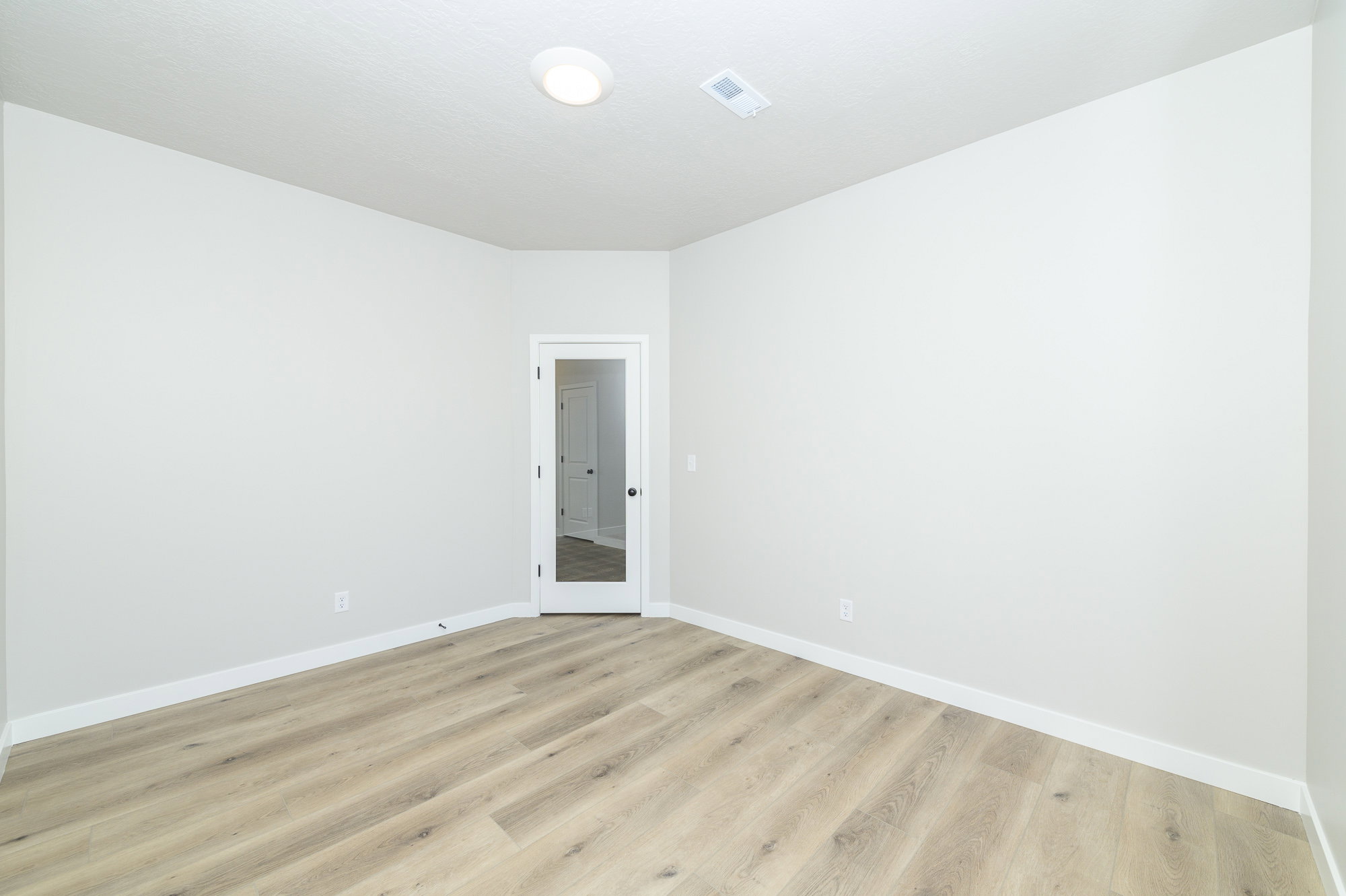 Spare room with baseboards and light wood finished floors