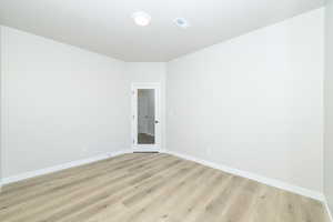 Spare room with baseboards and light wood finished floors