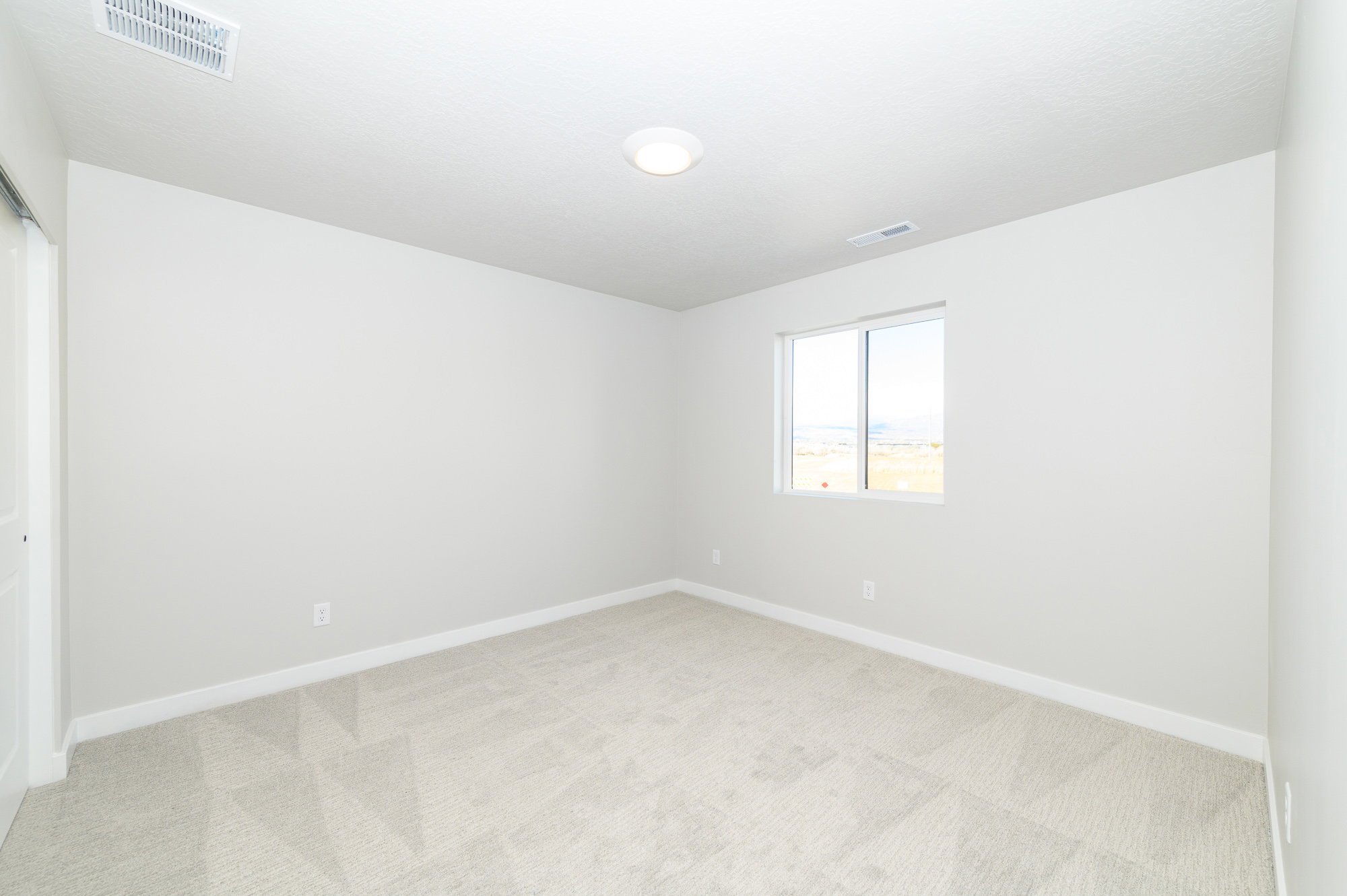 Spare room with light colored carpet and baseboards