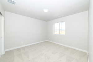 Spare room with light colored carpet and baseboards