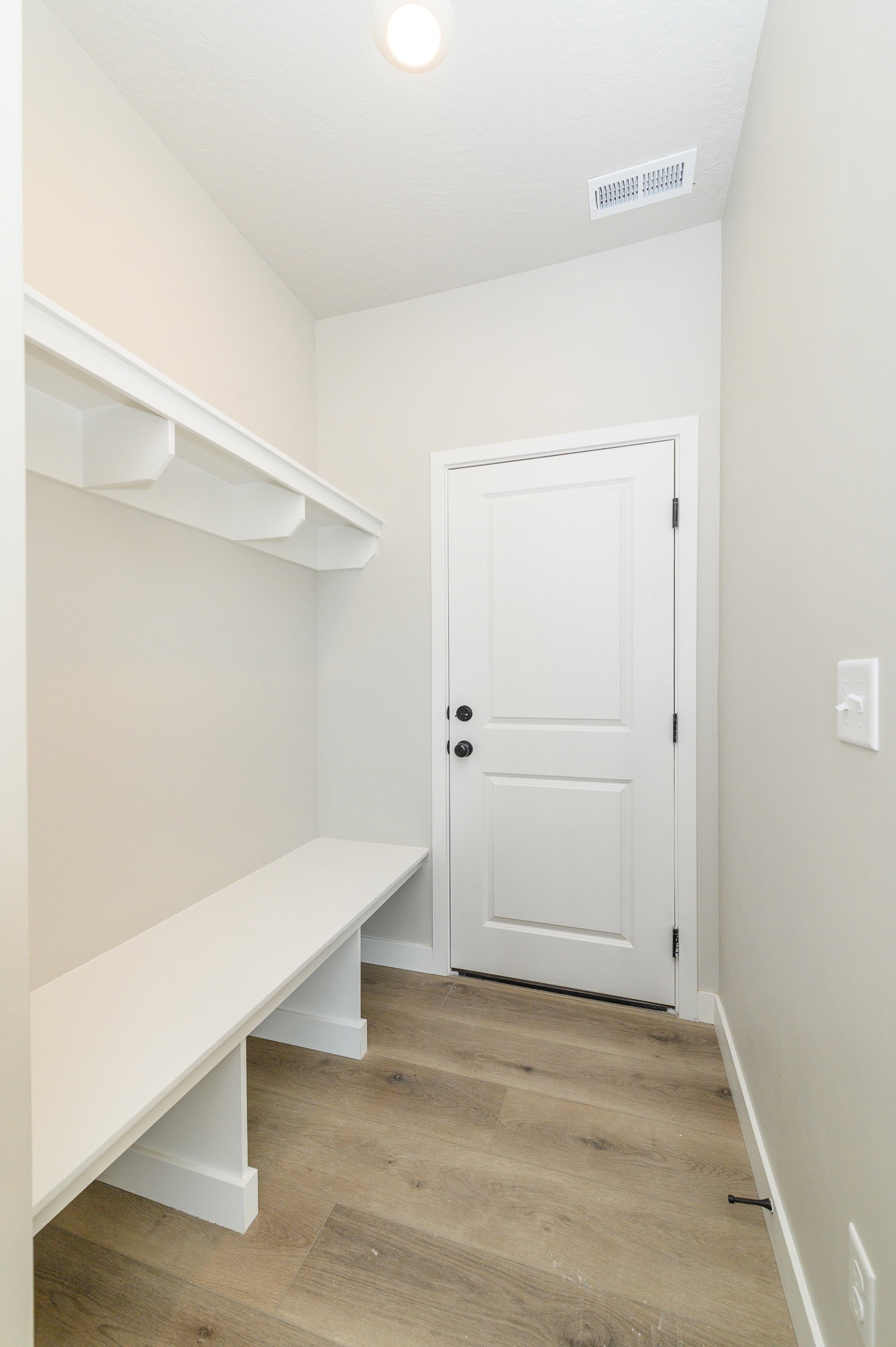 Mudroom with light wood finished floors and baseboards