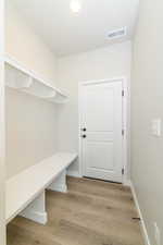 Mudroom with light wood finished floors and baseboards