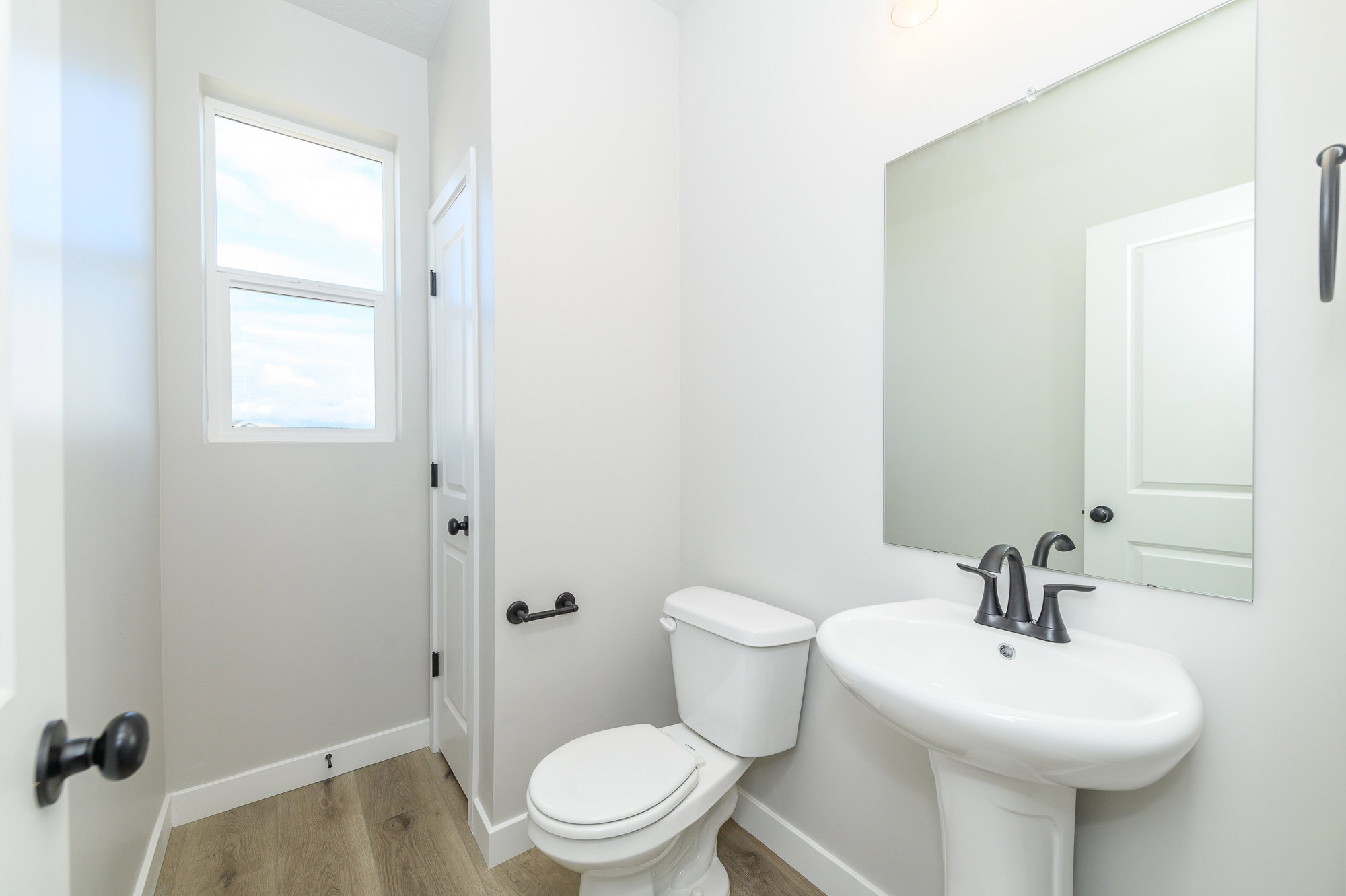Bathroom featuring toilet and light wood finished floors