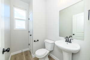 Bathroom featuring toilet and light wood finished floors