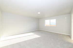 Unfurnished room featuring light colored carpet and baseboards