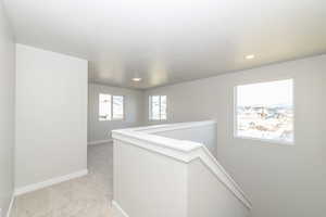 Hall with an upstairs landing and light carpet