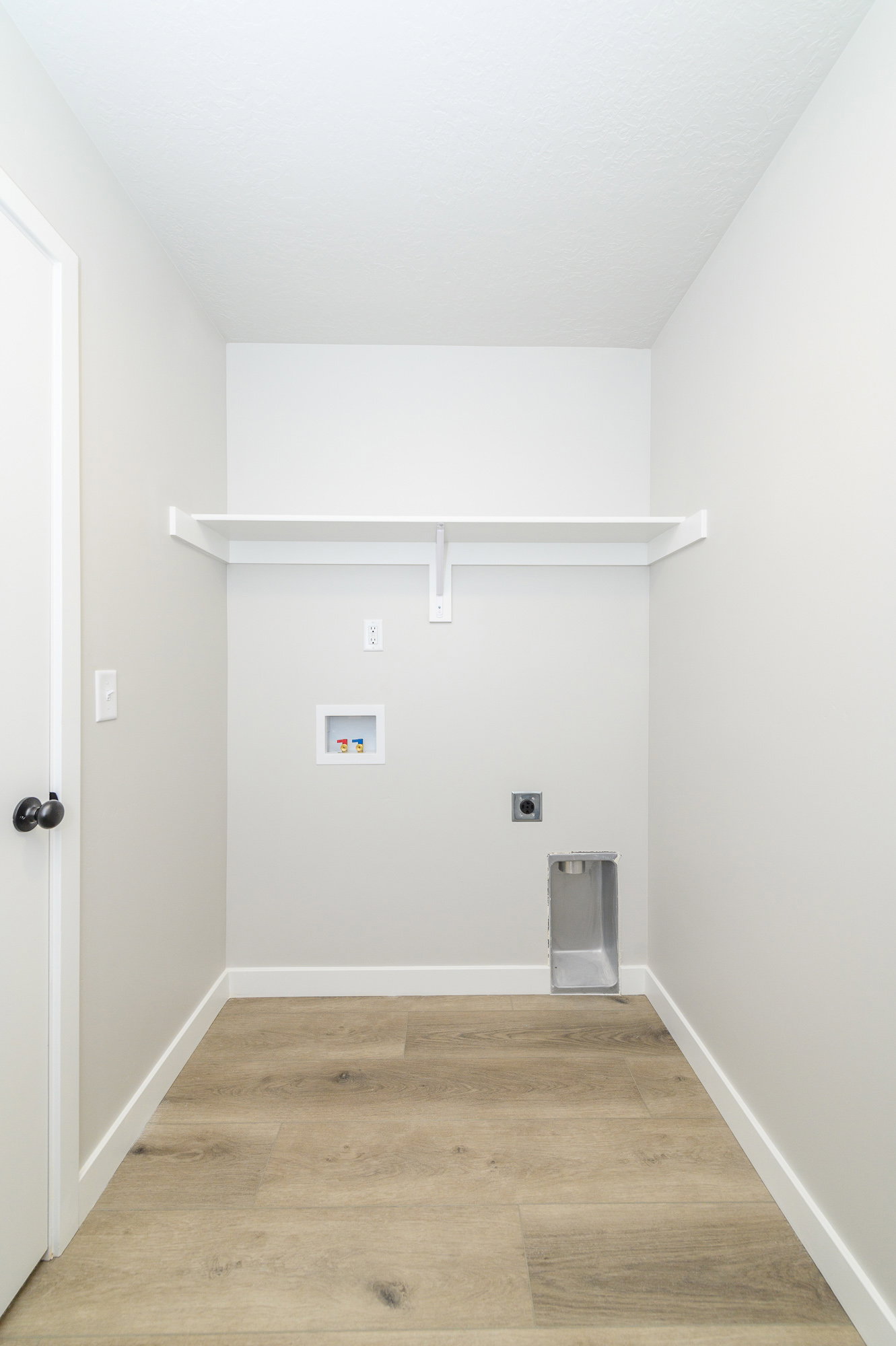Laundry room with light wood finished floors, electric dryer hookup, and hookup for a washing machine